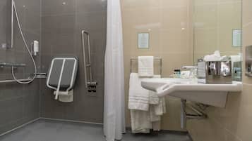 A modern bathroom with a shower, a toilet, a sink, and a towel rack.