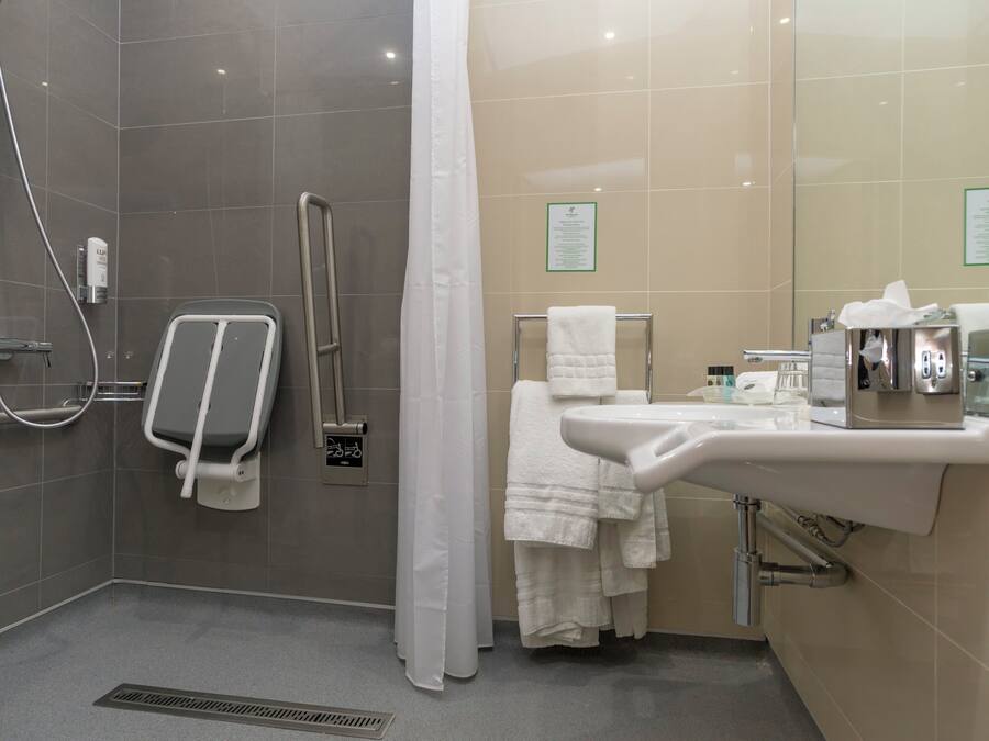 A modern bathroom with a shower, a toilet, a sink, and a towel rack.