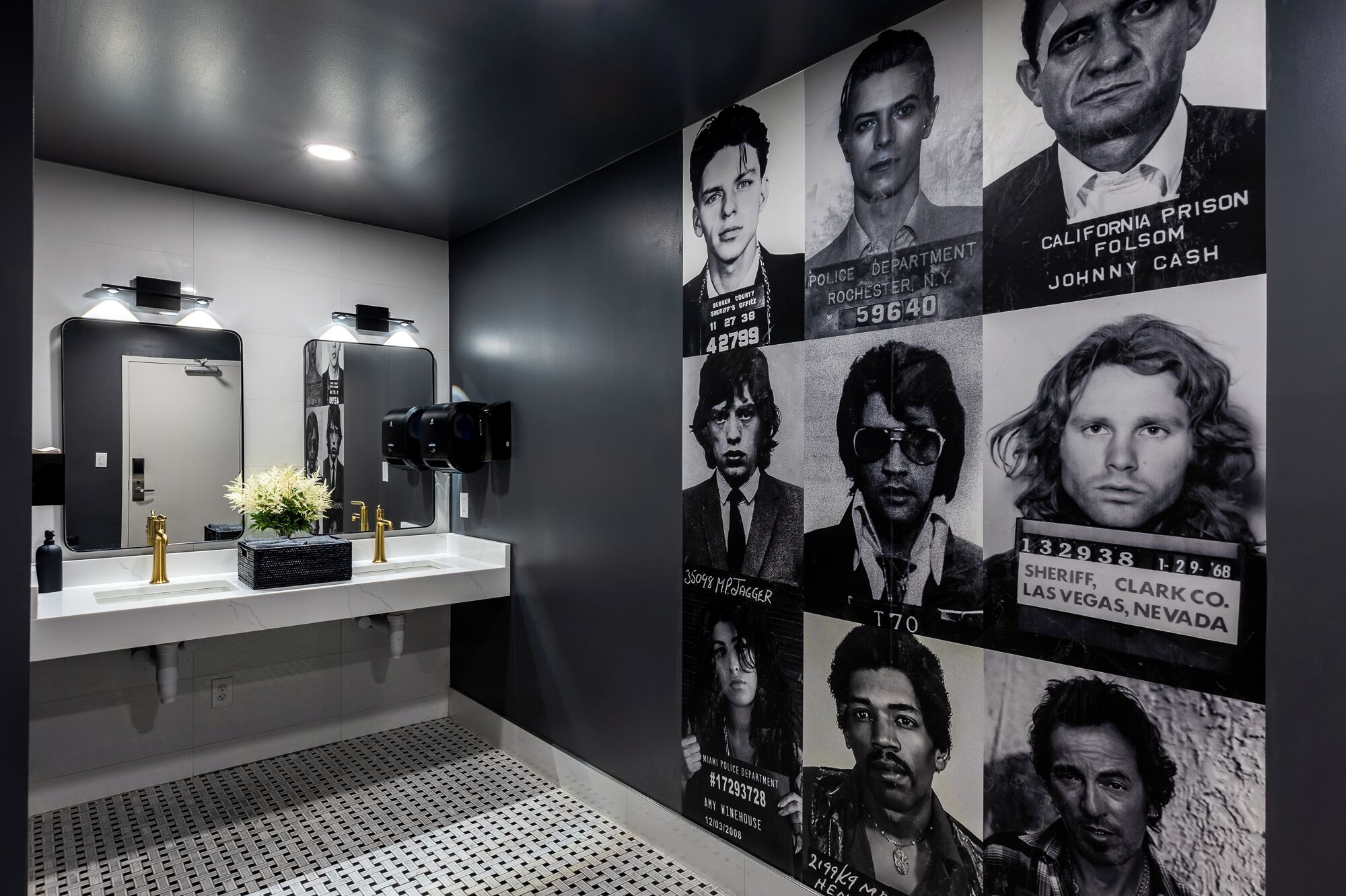 A modern bathroom with a large mirror, two sinks, and a wall-mounted camera.