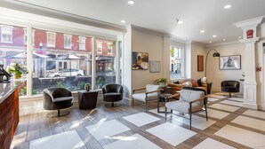A spacious lobby with a checkered floor, modern seating, and large windows offering a view of the street. - The Georgetown Inn (Washington)