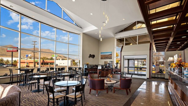 A spacious indoor area with multiple seating arrangements, large windows offering a view of the outside, and a modern interior design. - Best Western Plus Gold Country Inn (Winnemucca)
