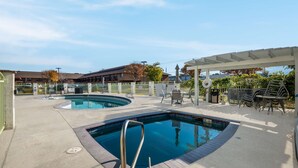A swimming pool area with two pools, lounge chairs, and a covered seating area. - Best Western Plus Gold Country Inn (Winnemucca)
