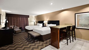 A hotel room with two beds, a desk, a chair, a small table, and a bar area. - Best Western Plus Gold Country Inn (Winnemucca)
