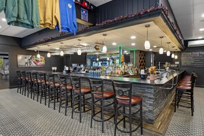 A bar area with a long counter, multiple stools, and a variety of bottles and glasses. - Best Western Hunt's Landing Hotel Matamoras/Milford (Matamoras)