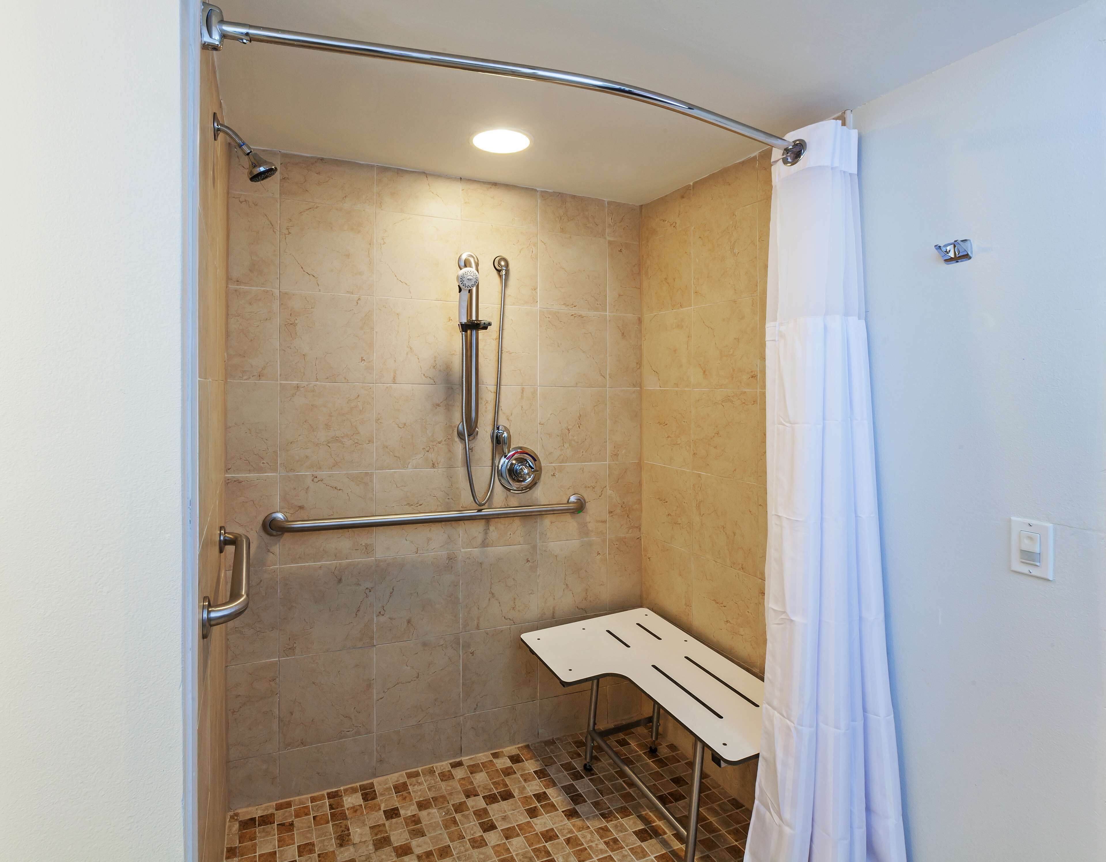 A shower with a handheld showerhead, a handheld showerhead, and a shower control.