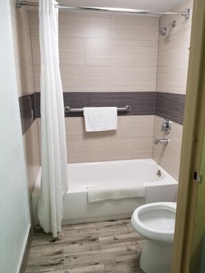 Un baño con ducha, bañera y retrete.