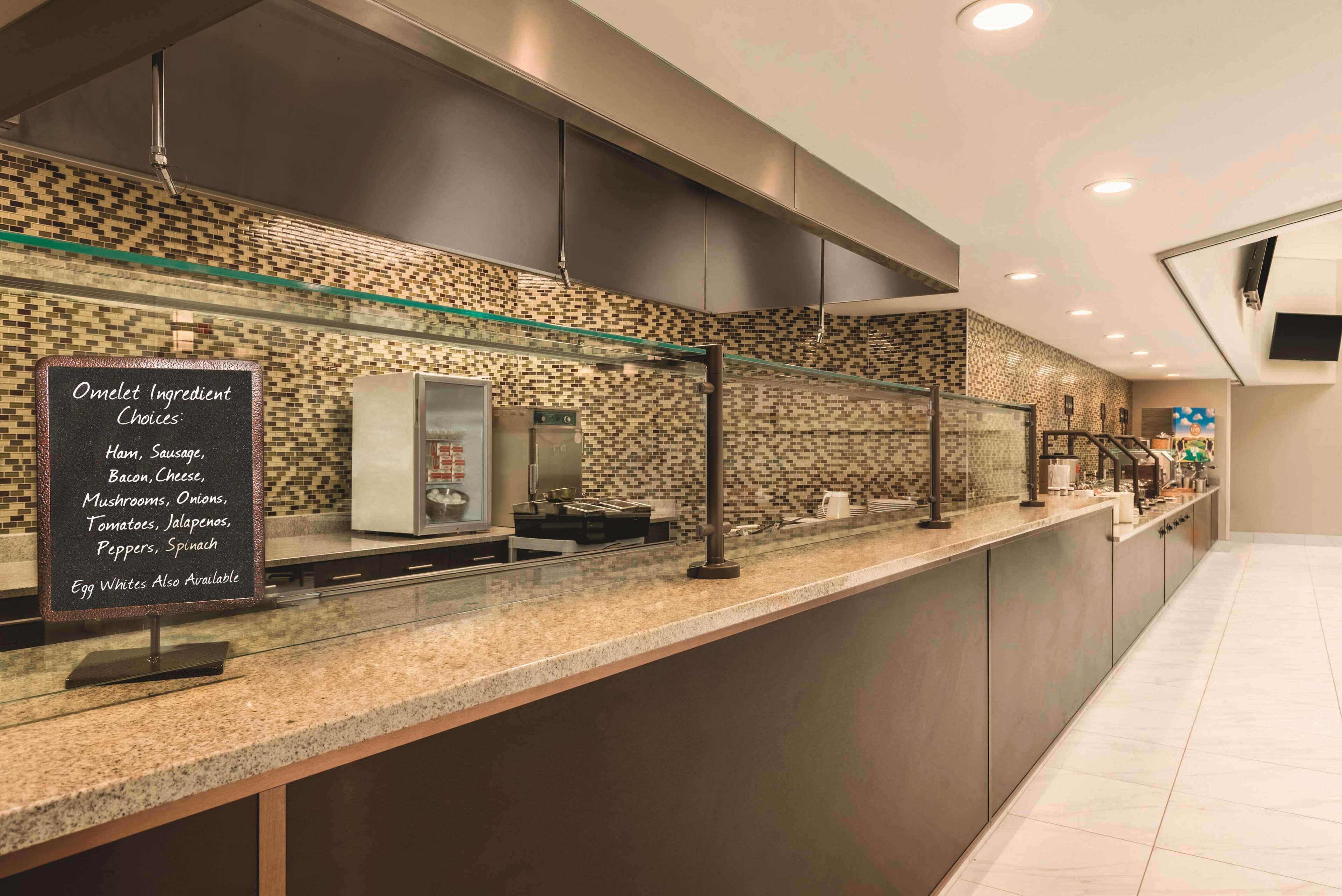 A modern breakfast bar with a chalkboard menu listing omelet ingredients and egg whites.