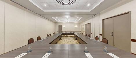 A conference room with a long table, chairs, and a chandelier.