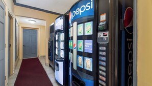 Un pasillo con dos máquinas expendedoras de Pepsi y una puerta al final.
