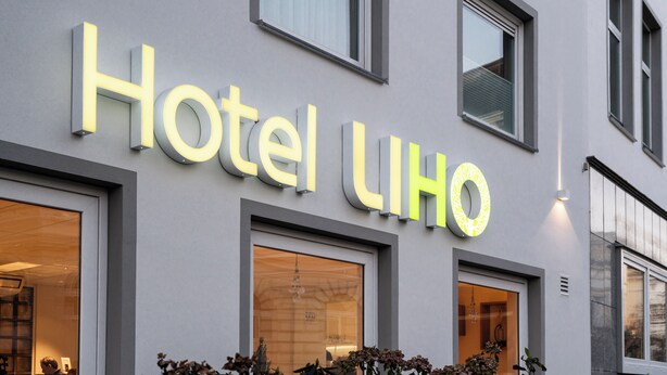 A hotel sign with the name "Hotel UHO" in illuminated letters.