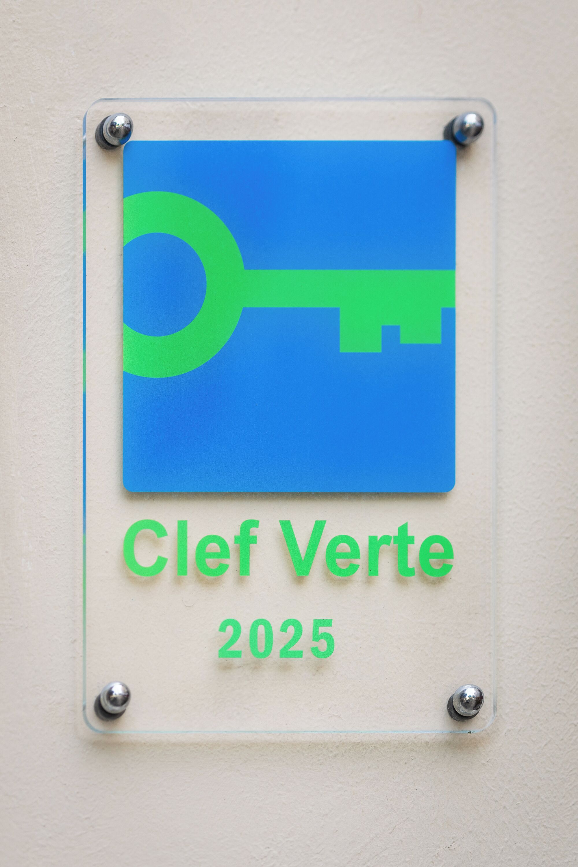 A sign with a key symbol and the text "Clef Verte 2025" mounted on a wall.