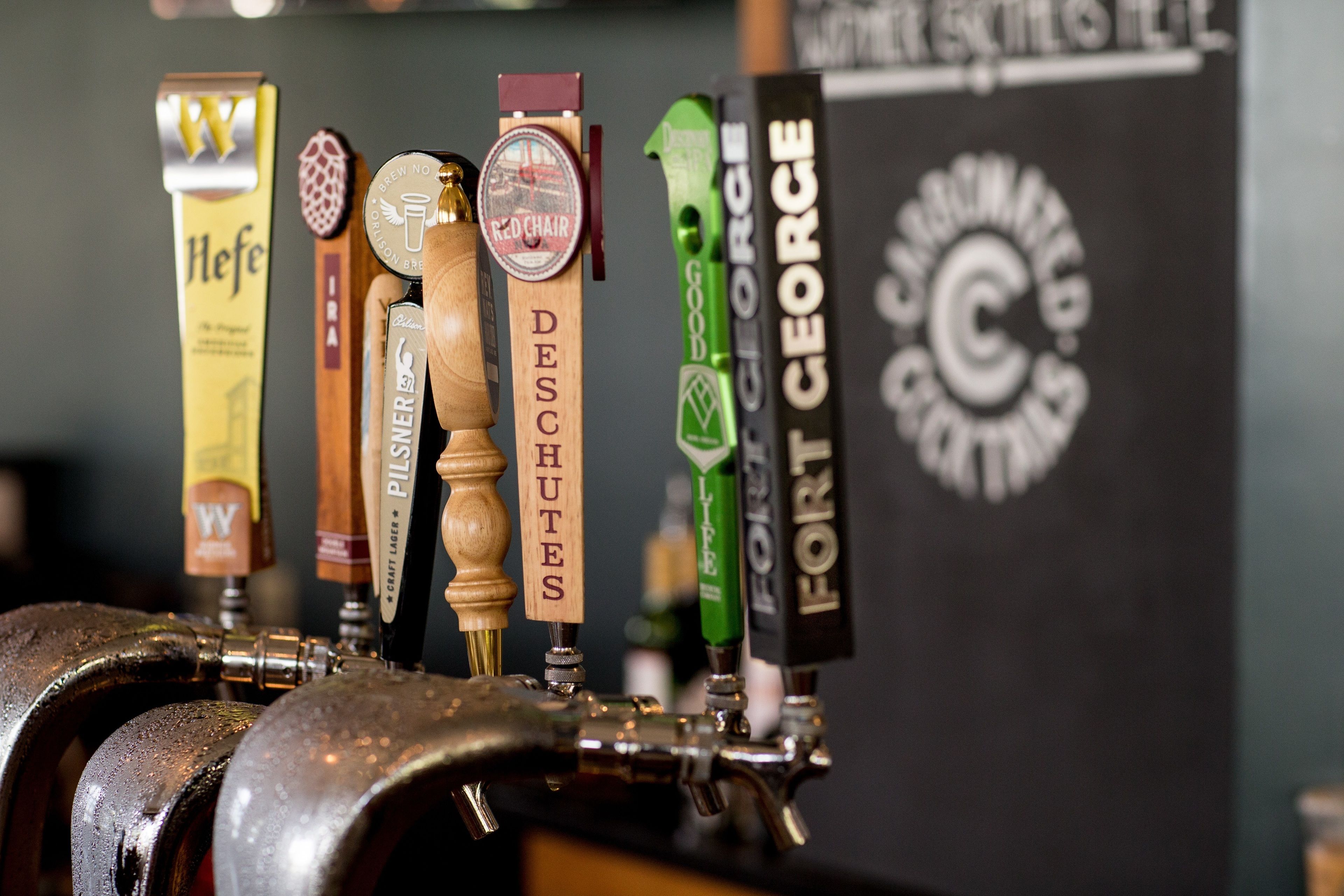A tap system with various beer taps labeled with names like 'Deschutes' and 'Fort George'.