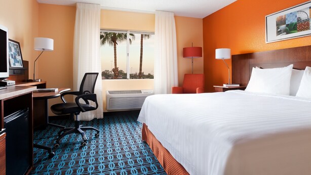 A hotel room with a bed, desk, chair, and a window with curtains. - Country Inn & Suites by Radisson, Phoenix Airport, AZ (Phoenix)