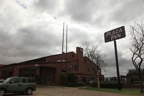 A brick building with a sign reading "Plaza Inn." - Plaza Inn (Midland)