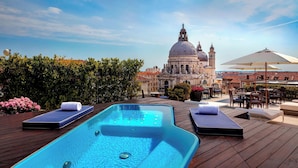 A rooftop pool area with lounge chairs and a view of a historic building in the background. - The Gritti Palace, a Luxury Collection Hotel, Venice (Venice)