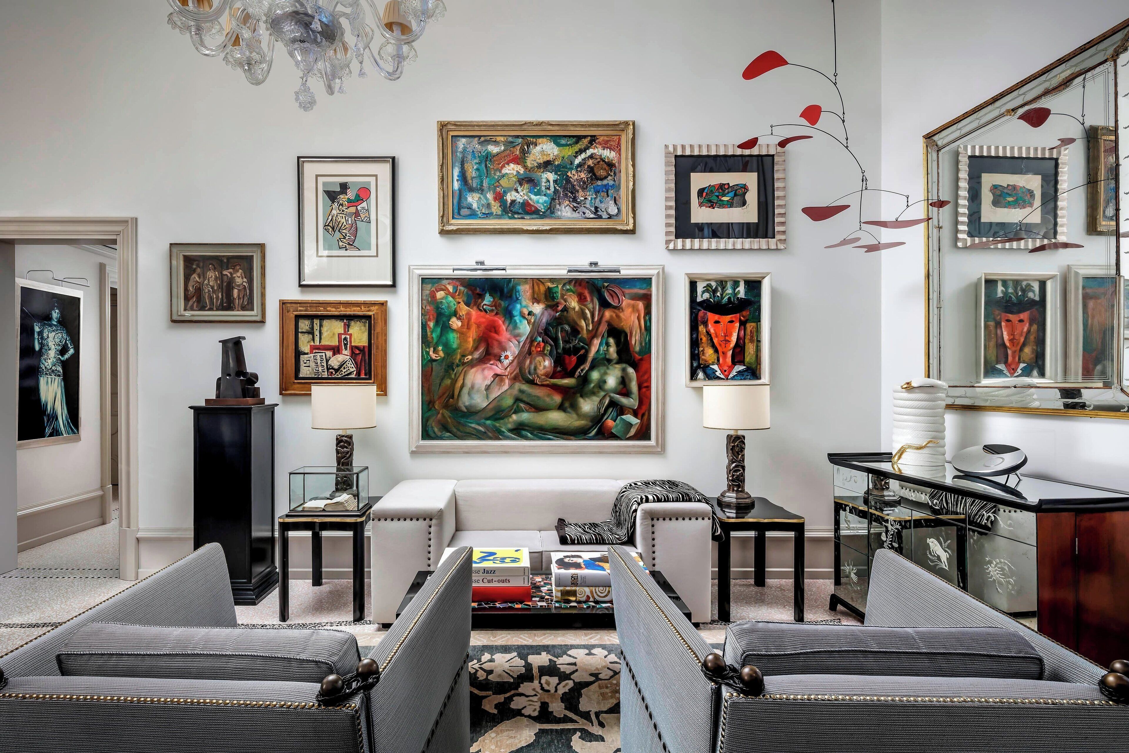 Un salon comprenant un canapé, une table basse et un grand tableau accroché au mur.