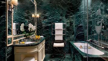 Un baño con lavamanos de mármol, toallero y bañera.
