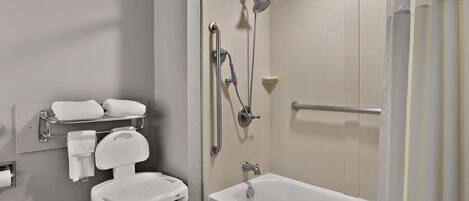 A bathroom with a bathtub, a shower, a toilet, and a chair.