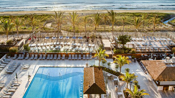 A resort with a swimming pool, sun loungers, and a view of the ocean. - Holiday Inn Ocean City by IHG (Ocean City)