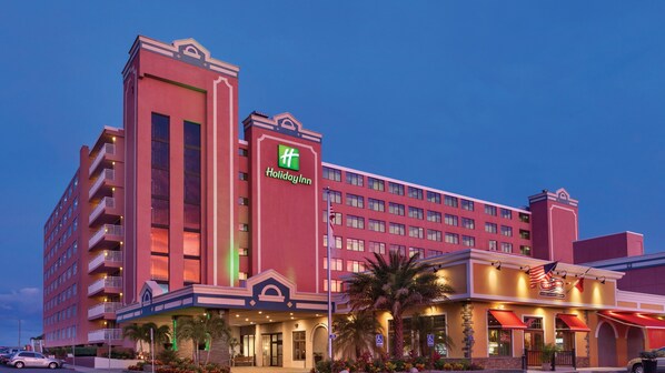 A multi-story Holiday Inn hotel with a prominent green logo, a flag, and a Touch of Italy restaurant.