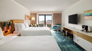 A hotel room with two beds, a desk, a chair, a TV, and a city view. - Holiday Inn Ocean City by IHG (Ocean City)