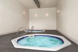 A spa room with two hot tubs, a metal ladder, and a ceiling vent. - Holiday Inn Ocean City by IHG (Ocean City)
