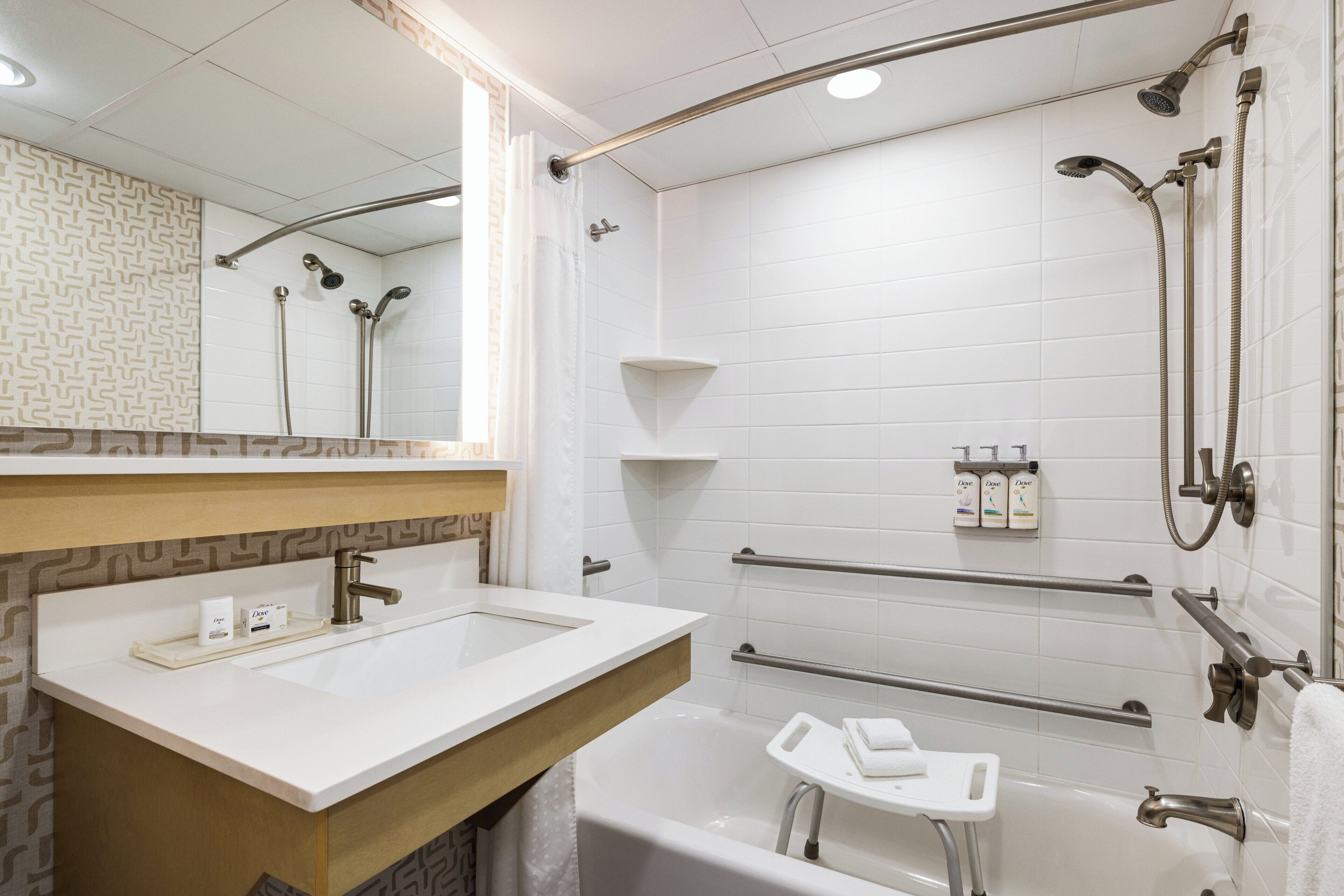 A modern bathroom with a white sink, a bathtub, and a shower area.