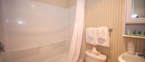A bathroom with a bathtub, toilet, and sink.