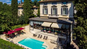 Un grand bâtiment doté d’une piscine, d’un espace extérieur aménagé et d’un jardin.