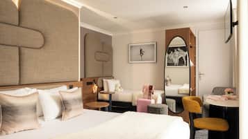 Ein Hotelzimmer mit einem großen Bett, einer Sitzecke mit Sessel und Tisch, einem Spiegel und einem kleinen Nachttisch.