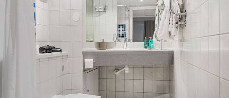 Un baño moderno con ducha, inodoro y lavamanos.