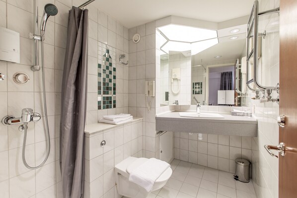 Un baño moderno con ducha, inodoro y lavamanos.