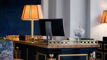 Un mostrador de recepción de hotel con una computadora, adornos y una lámpara.