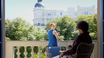 A balcony with a view of a building with a dome and trees in the background.
