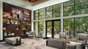 A spacious lobby with a large window, a bookshelf, and seating area. - Atlanta Marriott Northwest at Galleria (Atlanta)