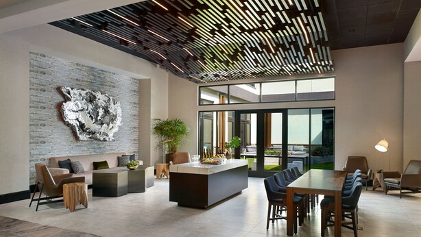 A spacious, modern interior with a central island, seating area, and large windows offering views. - Atlanta Marriott Northwest at Galleria (Atlanta)