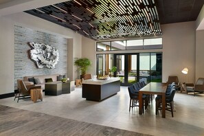 A spacious, modern interior with a central island, seating area, and large windows offering views. - Atlanta Marriott Northwest at Galleria (Atlanta)