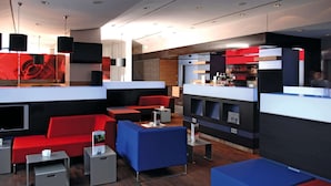 A modern lobby with red and blue seating, a reception desk, and a bar area. - IntercityHotel Hamburg-Altona (Hamburg)