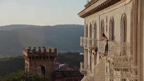 A historic building with a balcony overlooking a mountainous landscape. - Sina Brufani (Perugia)