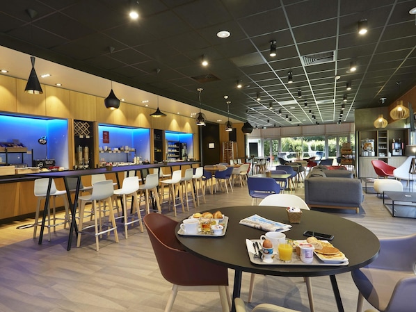 A modern cafe with a bar area, seating, and breakfast items on tables.