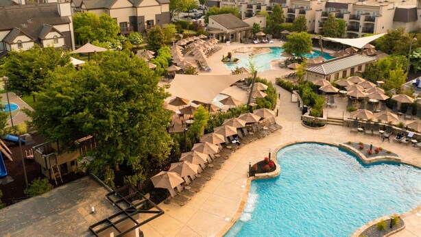 An aerial view of a resort with a large swimming pool, sun loungers, and a children's play area. - Eden Resort and Suites, BW Premier Collection (Lancaster)