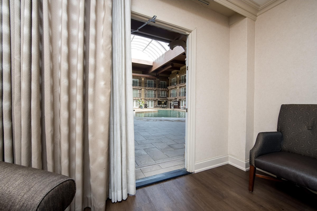 Una habitación con vistas a una piscina y un balcón.