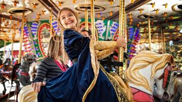 Un carrousel doté de piliers dorés richement décorés et d’ornements colorés.