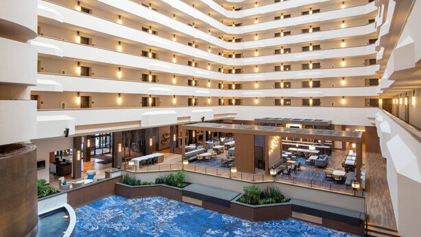 A multi-level hotel atrium with a central pool, multiple floors, and a variety of seating areas. - Marriott Madison West (Madison)