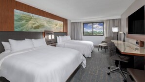A hotel room with two beds, a desk, a chair, a TV, and a window with a view of the outdoors. - Marriott Madison West (Madison)