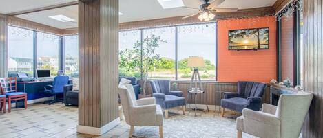 A spacious room with a large window, a ceiling fan, and a fireplace.