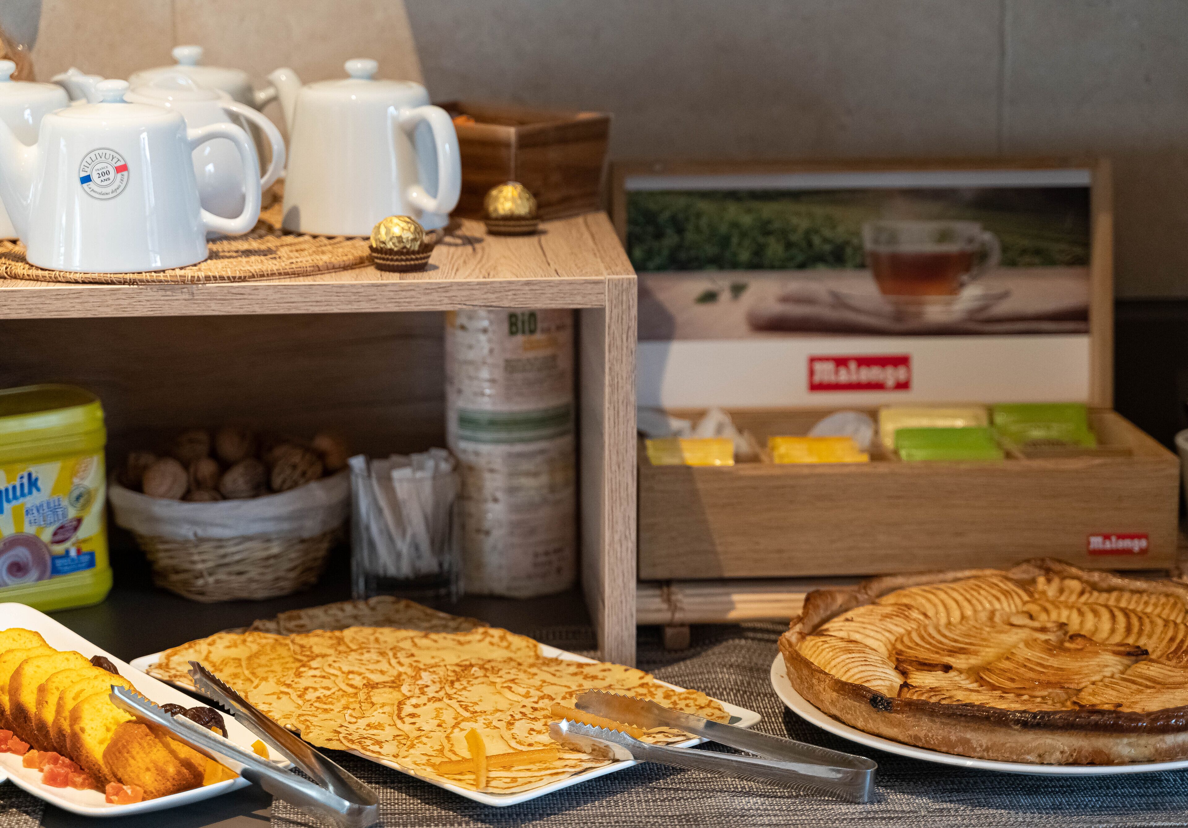 Un bufé de desayuno con diversas opciones de comida, incluyendo pasteles, un pastel y salsas.