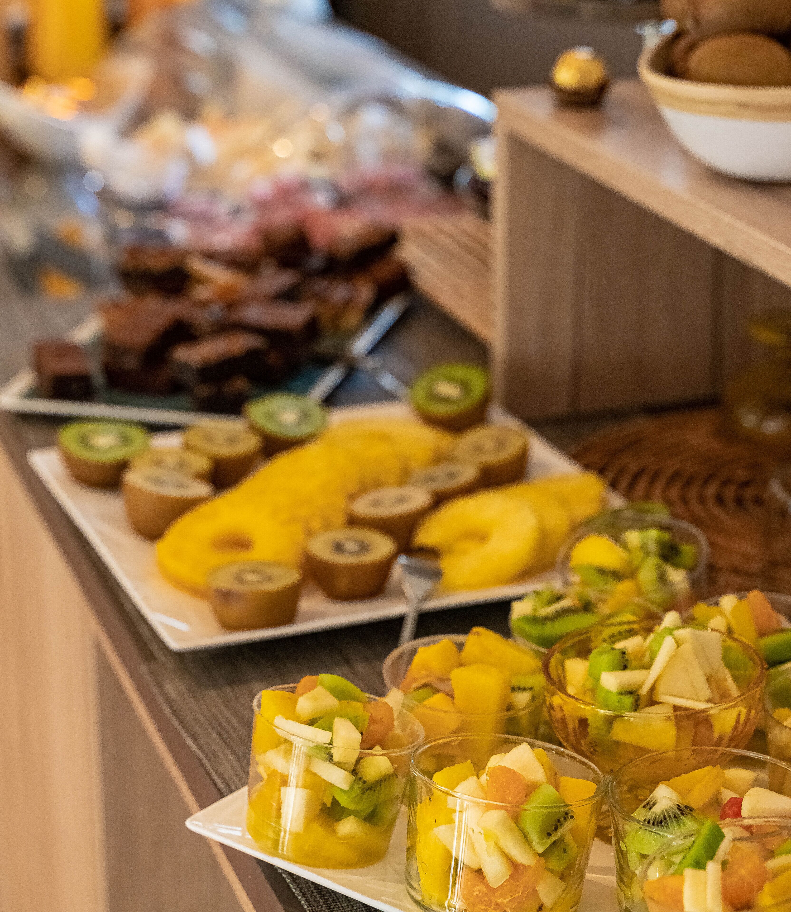 A buffet with various fruits and a selection of meats.