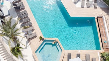 Una piscina al aire libre de temporada, sombrillas, tumbonas