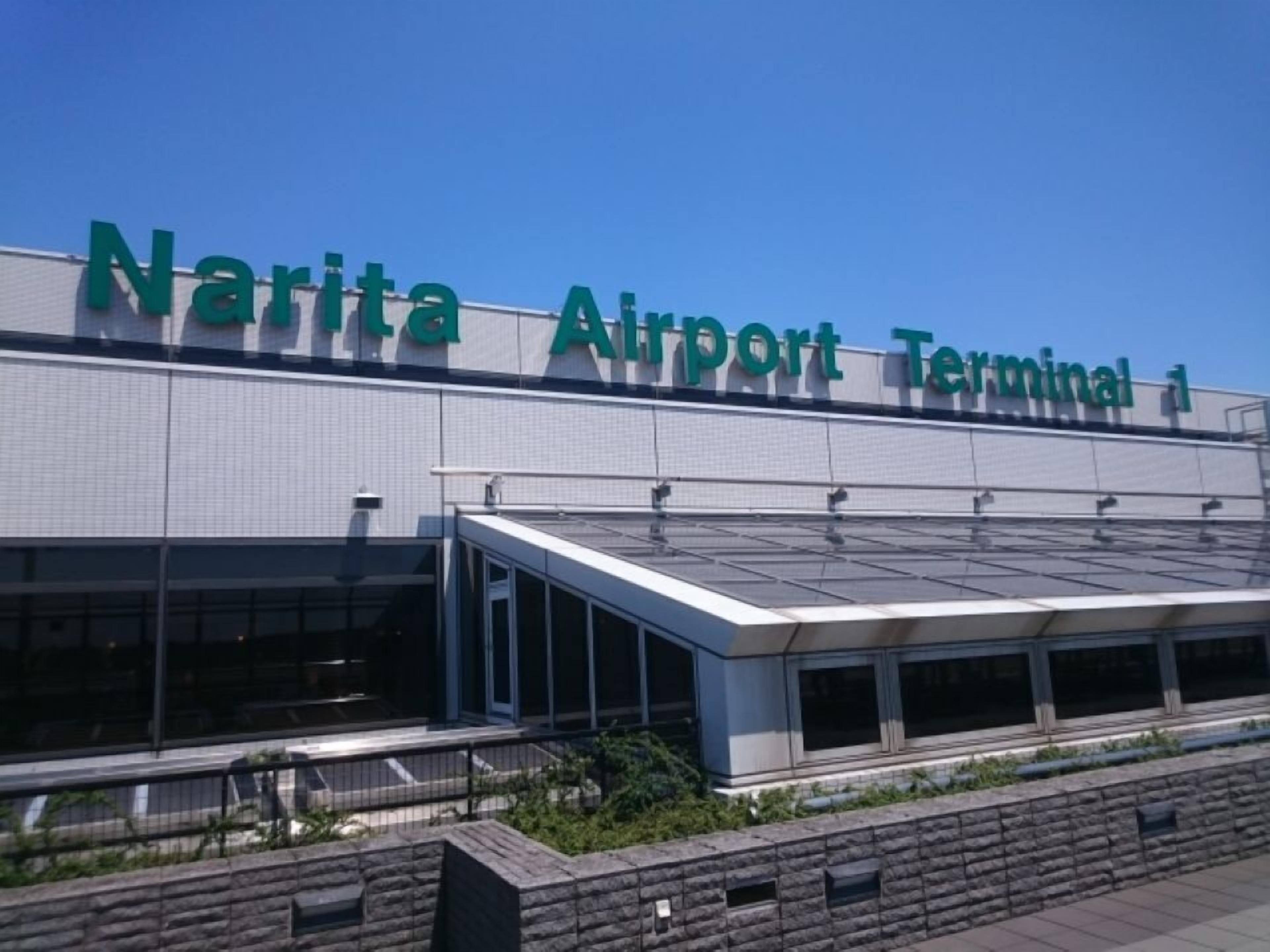 Terminal 1 del Aeropuerto de Narita, con un diseño moderno, ventanas amplias y un pasillo cubierto.
